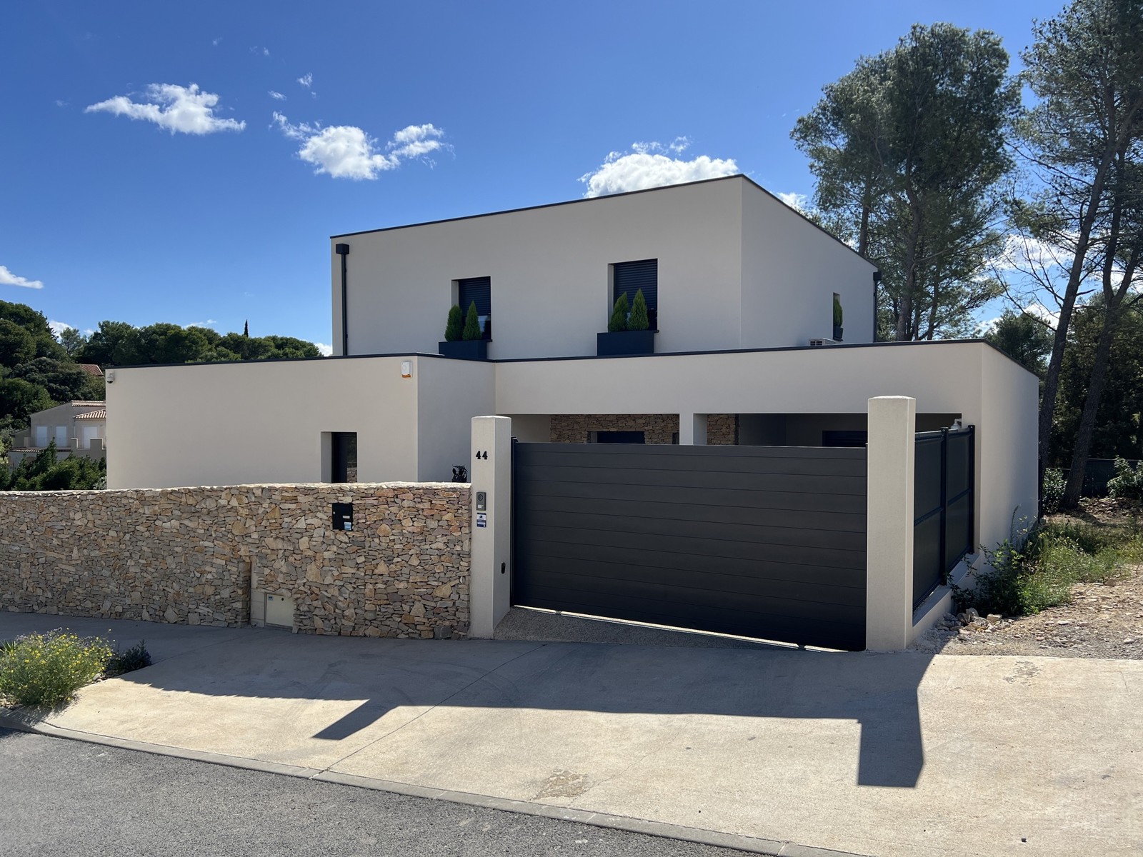 Maison contemporaine avec façade enduite claire et menuiseries anthracite